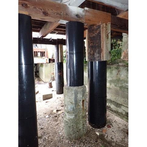 Piles beneath the house with black repair jackets around the timber supports.